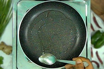 add oil in pan with spoon