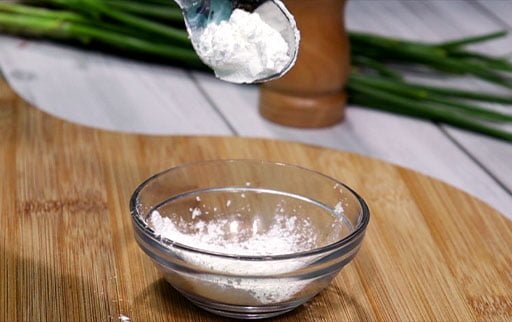 pour-cornflour-in-small-glass-bowl-by-spoon