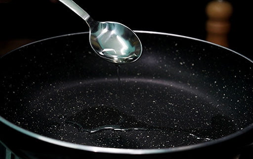 pour-oil-with-spoon-in-pan