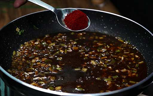 add-kashmiri-red-chilli-powder-by-spoon