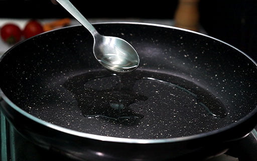 pour-oil-in-pan-by-spoon