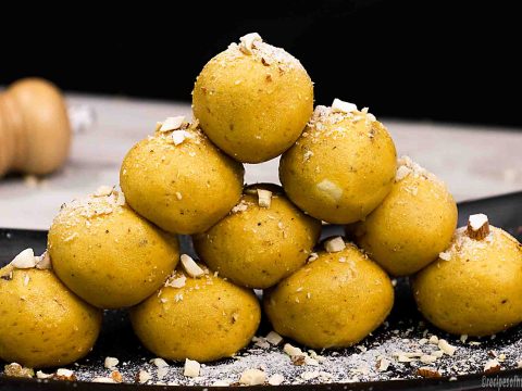 best-homemade-besan-ladoo-recipe-served-on-black-plate-with-sprinkle-chopped-dried-fruits