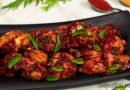 chicken-65-recipe-served-on-black-plate=garnish-with-fresh-curry-leaves