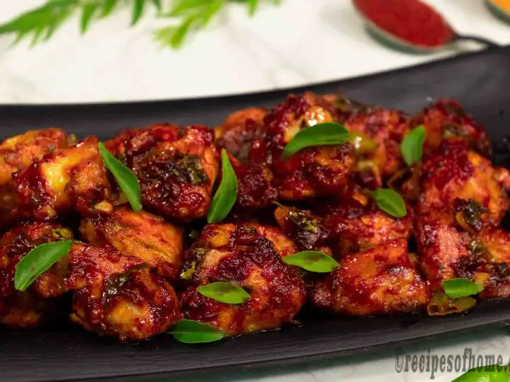 chicken-65-recipe-served-on-black-plate=garnish-with-fresh-curry-leaves