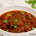 spicy-chicken-masala-recipe-serve-on-white-serving-bowl-sprinkling-chopped-coriander-leaves