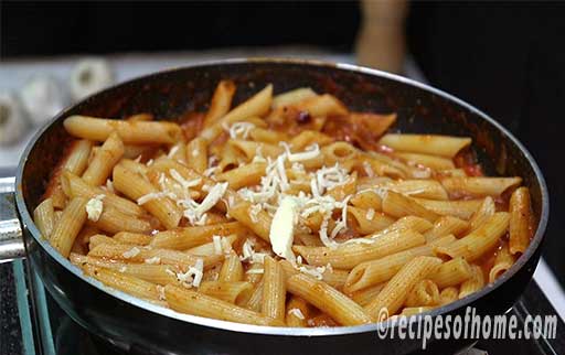 garnish pasta in red sauce with grated cheese