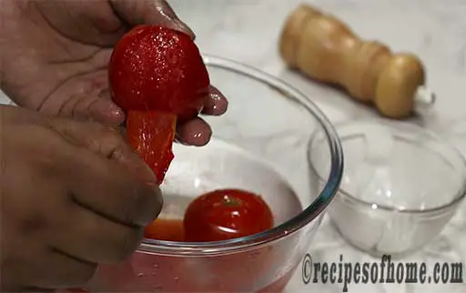 pour tomatoes and red chili in cold water and remove tomatoes skin
