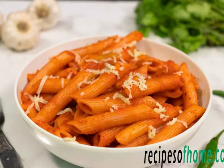 red sauce pasta recipe serve on white bowl garnish with grated cheese from top