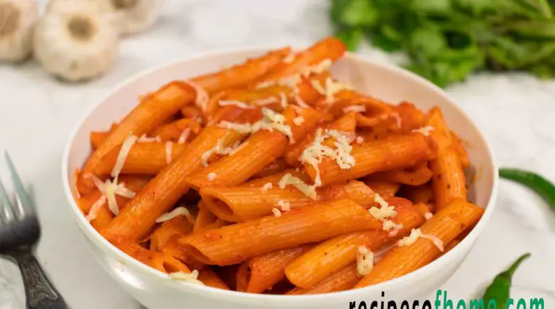 red sauce pasta recipe serve on white bowl garnish with grated cheese from top