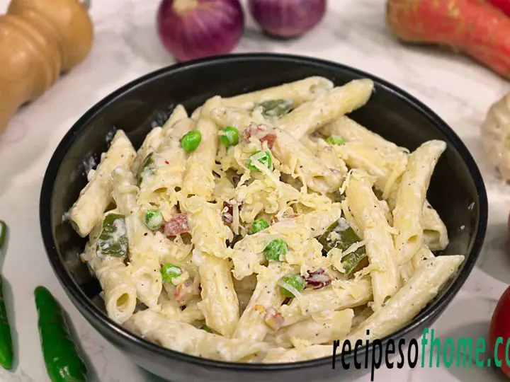 Italian white sauce pasta recipe serve on black bowl garnish with grated chees