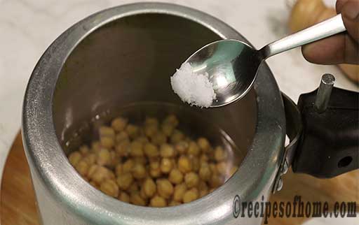 pour soaked chole in pressure cooker,sprinkle pinch of salt in it