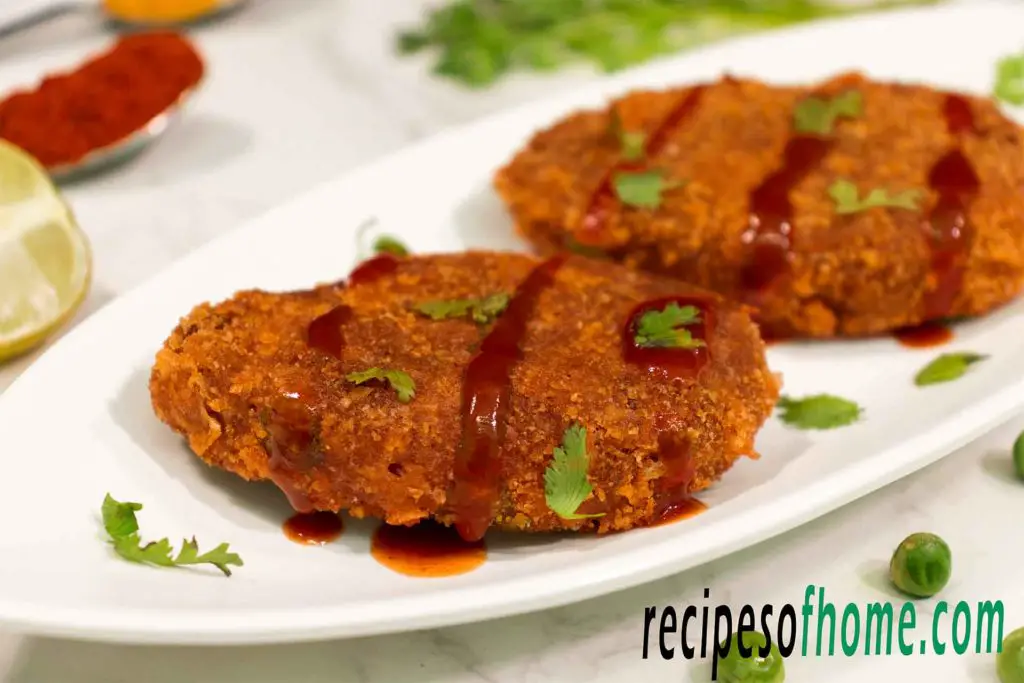 crispy veg cutlet recipe serve on white plate garnish with tomato ketchup and chopped coriander leaves