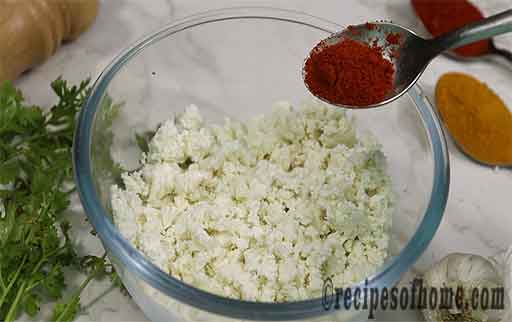 sprinkle red chilli powder with scrambled paneer