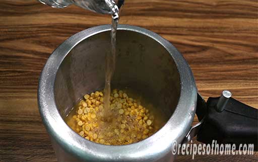 pour soaked dal, turmeric powder, pinch of salt , water in a pressure cooker