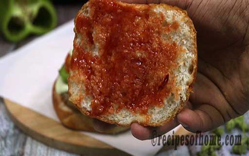 apply tomato ketchup on top layer of burger bun