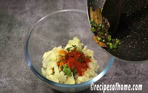 in a mixing bowl mix red chili powder , turmeric powder , coriander leaves and tempering