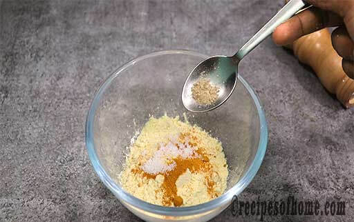 in a bowl add besan , turmeric powder , salt , pinch of hing